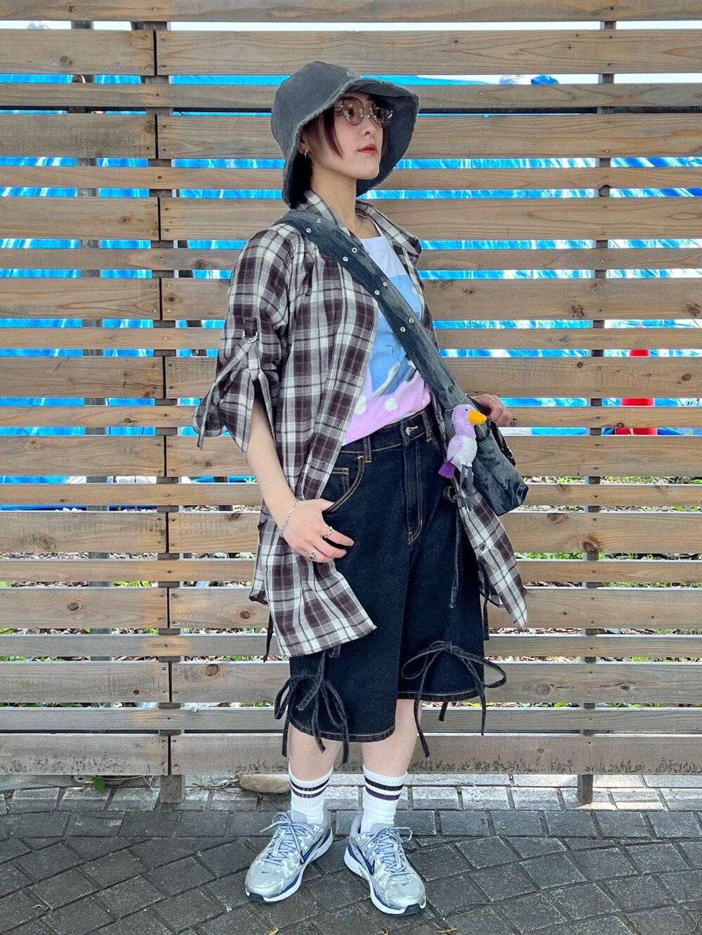 ブラウン系のシャツ/ブラウス、ブラック系のデニムパンツ、ブラック系のメッセンジャーバッグを着用したレディースの春コーディネートの2枚目の写真