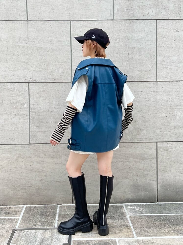 ブラック系のデニムパンツ、ホワイト系のTシャツ/カットソー、ブラック系のブーツを着用したレディースの秋コーディネートの5枚目の写真