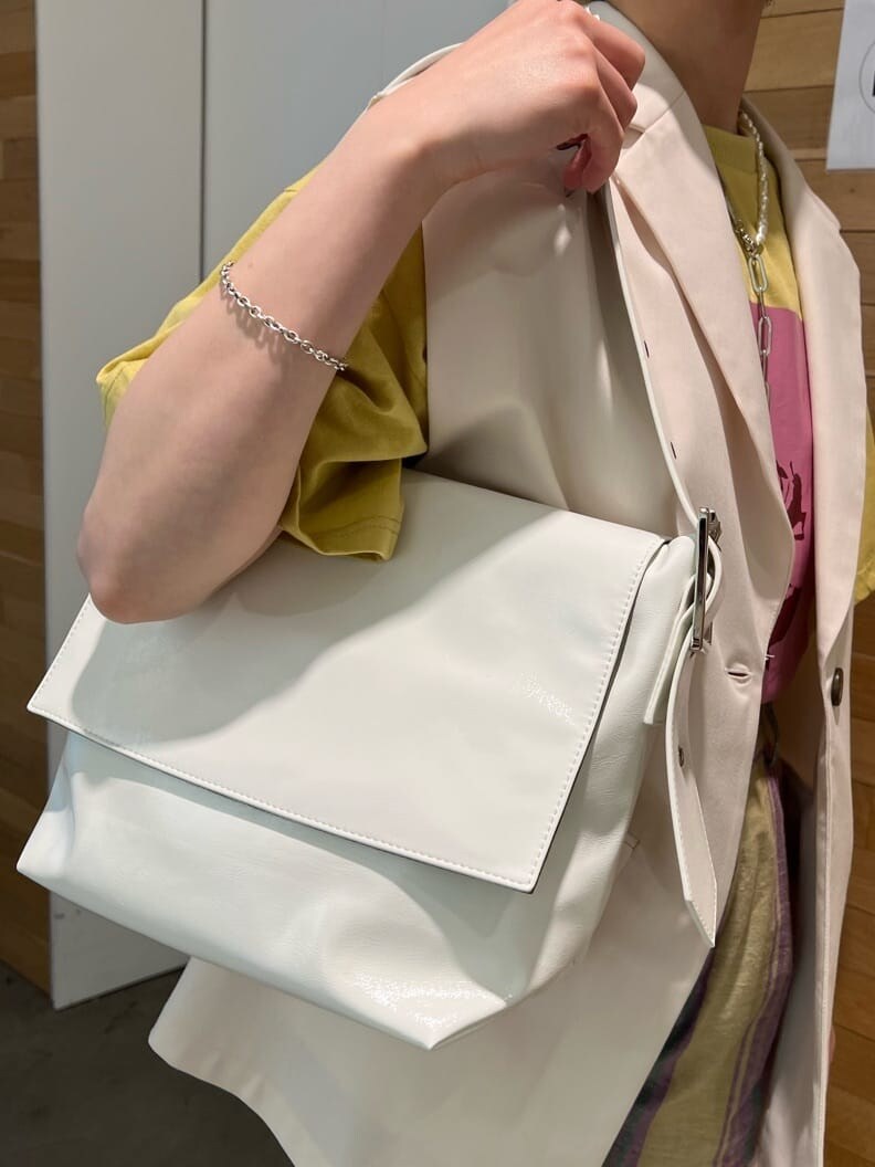 ホワイト系のブーツ、ホワイト系のベスト、ホワイト系のハンドバッグを着用したレディースの春コーディネートの9枚目の写真