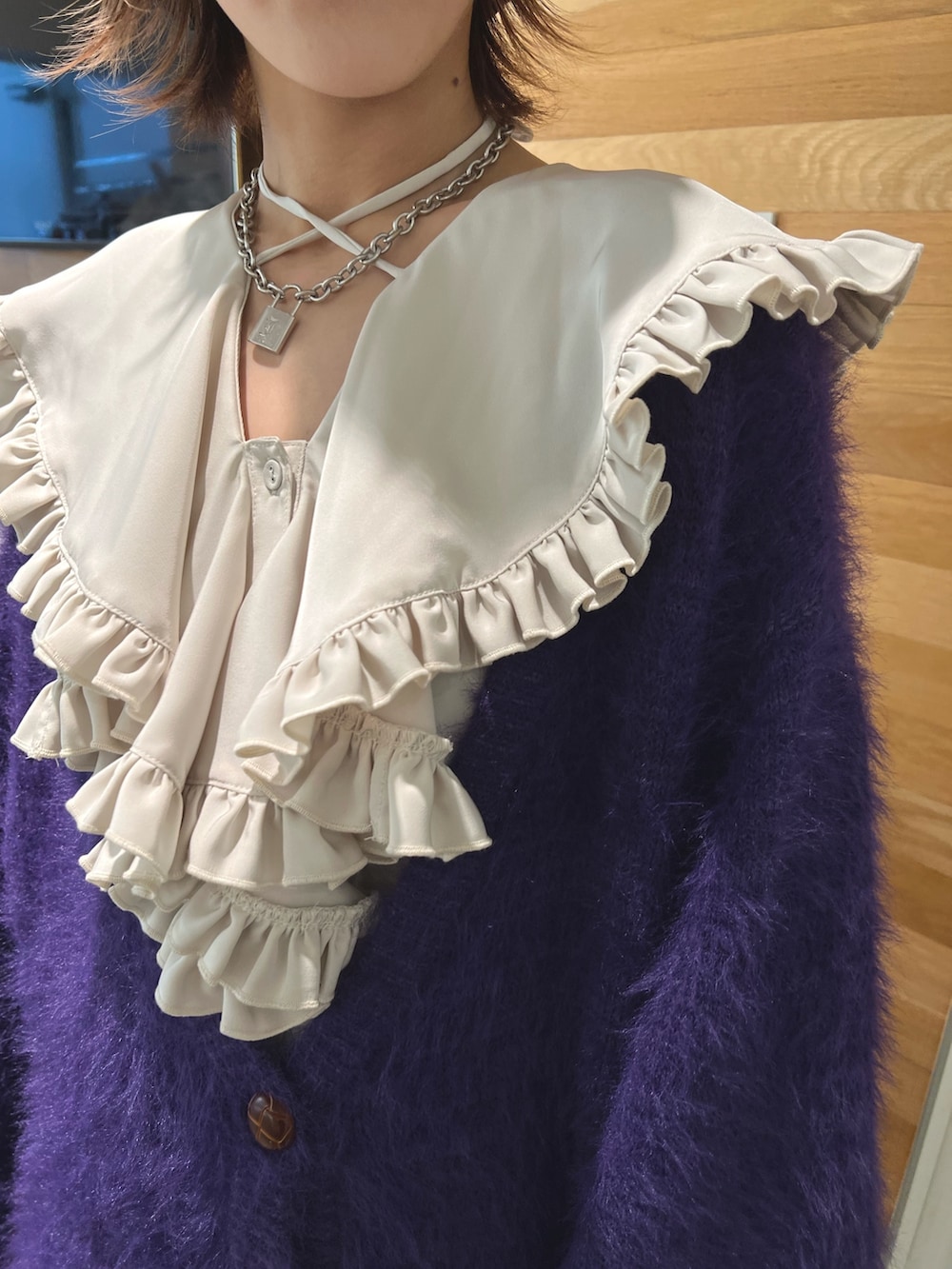 ホワイト系のシャツ/ブラウス、パープル系のカーディガン/ボレロ、ブラック系のデニムパンツを着用したレディースの冬コーディネートの6枚目の写真