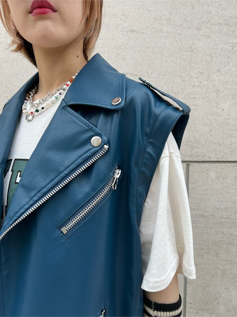 ブラック系のデニムパンツ、ホワイト系のTシャツ/カットソー、ブラック系のブーツを着用したレディースの秋コーディネートの9枚目の写真