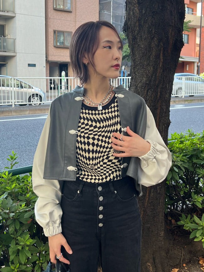 ブラック系のニット/セーター、ホワイト系のスニーカー、ブラック系のデニムパンツを着用したレディースの秋コーディネートの6枚目の写真