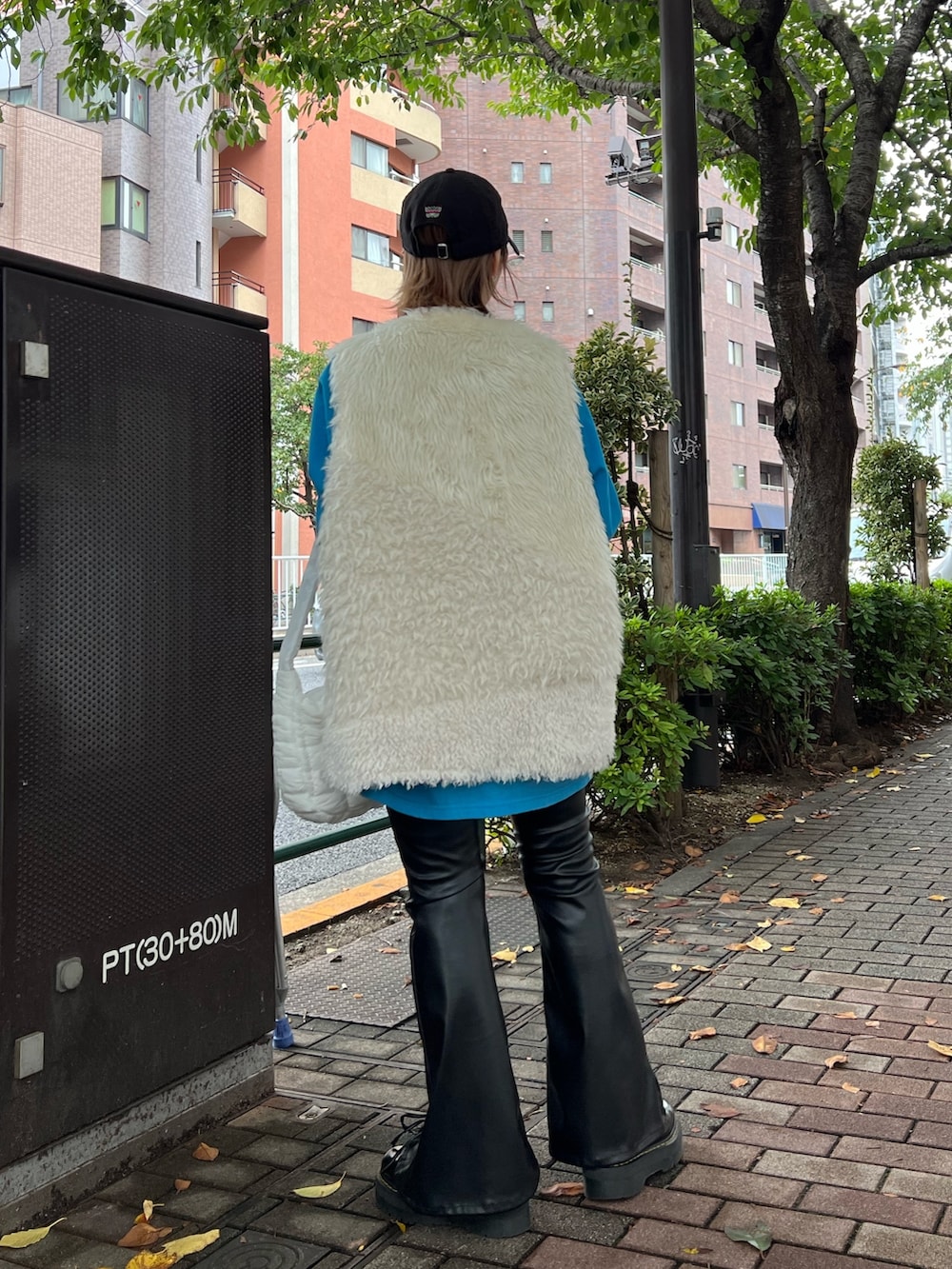 ブルー系のTシャツ/カットソー、ホワイト系のベスト、ホワイト系のハンドバッグを着用したレディースの冬コーディネートの3枚目の写真