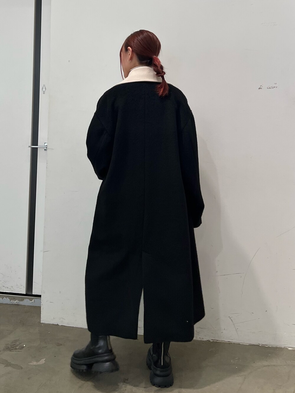 その他のニット/セーター、ブルー系のスカート、ブラック系のチェスターコートを着用したレディースの秋コーディネートの4枚目の写真