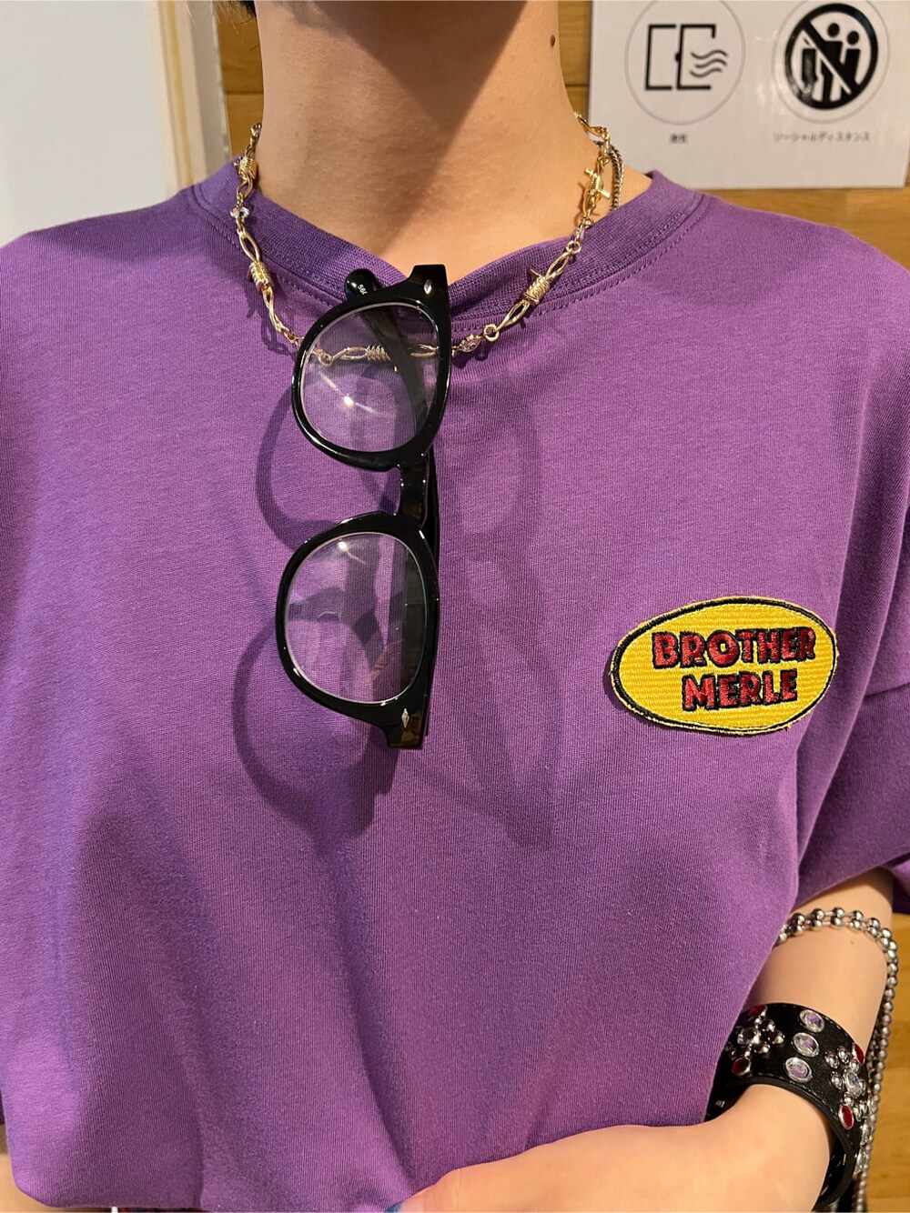 ブラック系のその他シューズ、ブラック系のトートバッグ、パープル系のTシャツ/カットソーを着用したレディースの夏コーディネートの6枚目の写真