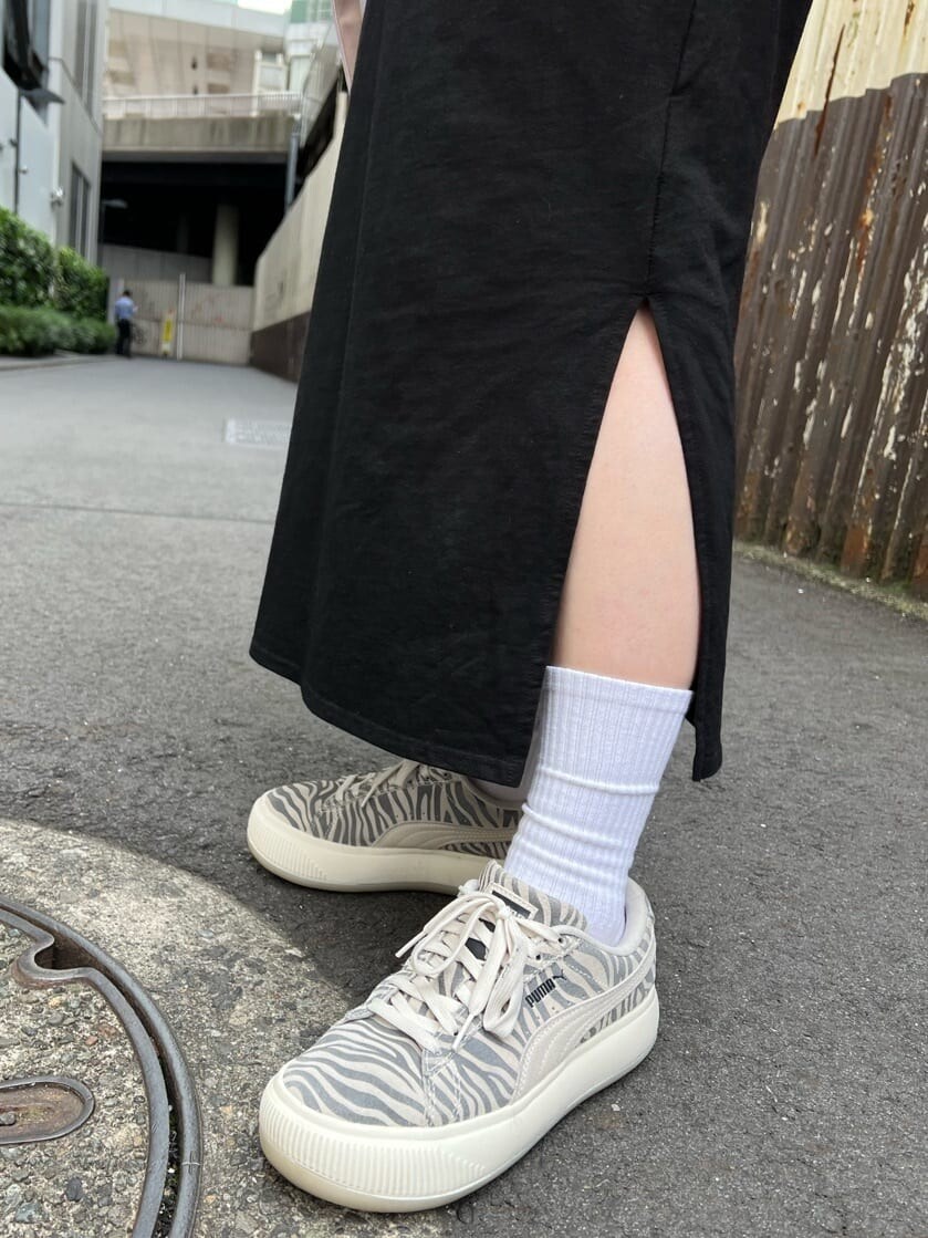 ブラック系のワンピース、パープル系のハンドバッグ、グリーン系のキャップを着用したレディースの夏コーディネートの8枚目の写真