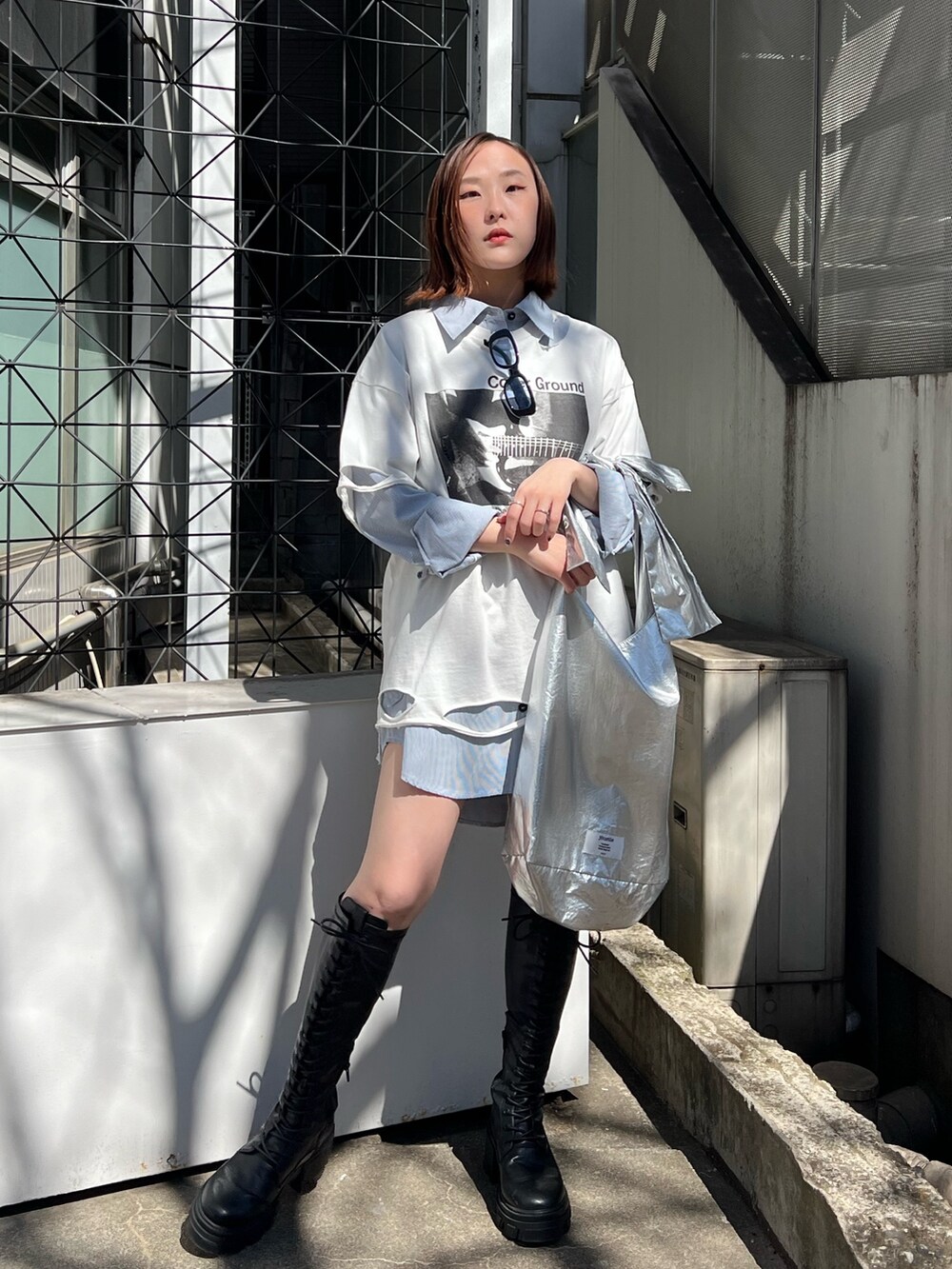 シルバー系のトートバッグ、ブルー系のシャツ/ブラウス、ホワイト系のTシャツ/カットソーを着用したレディースの春コーディネートの5枚目の写真