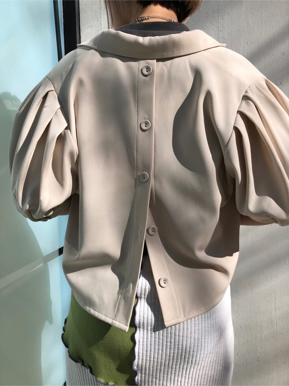 ホワイト系のテーラードジャケット、グリーン系のスカート、ブラック系のTシャツ/カットソーを着用したレディースの春コーディネートの7枚目の写真