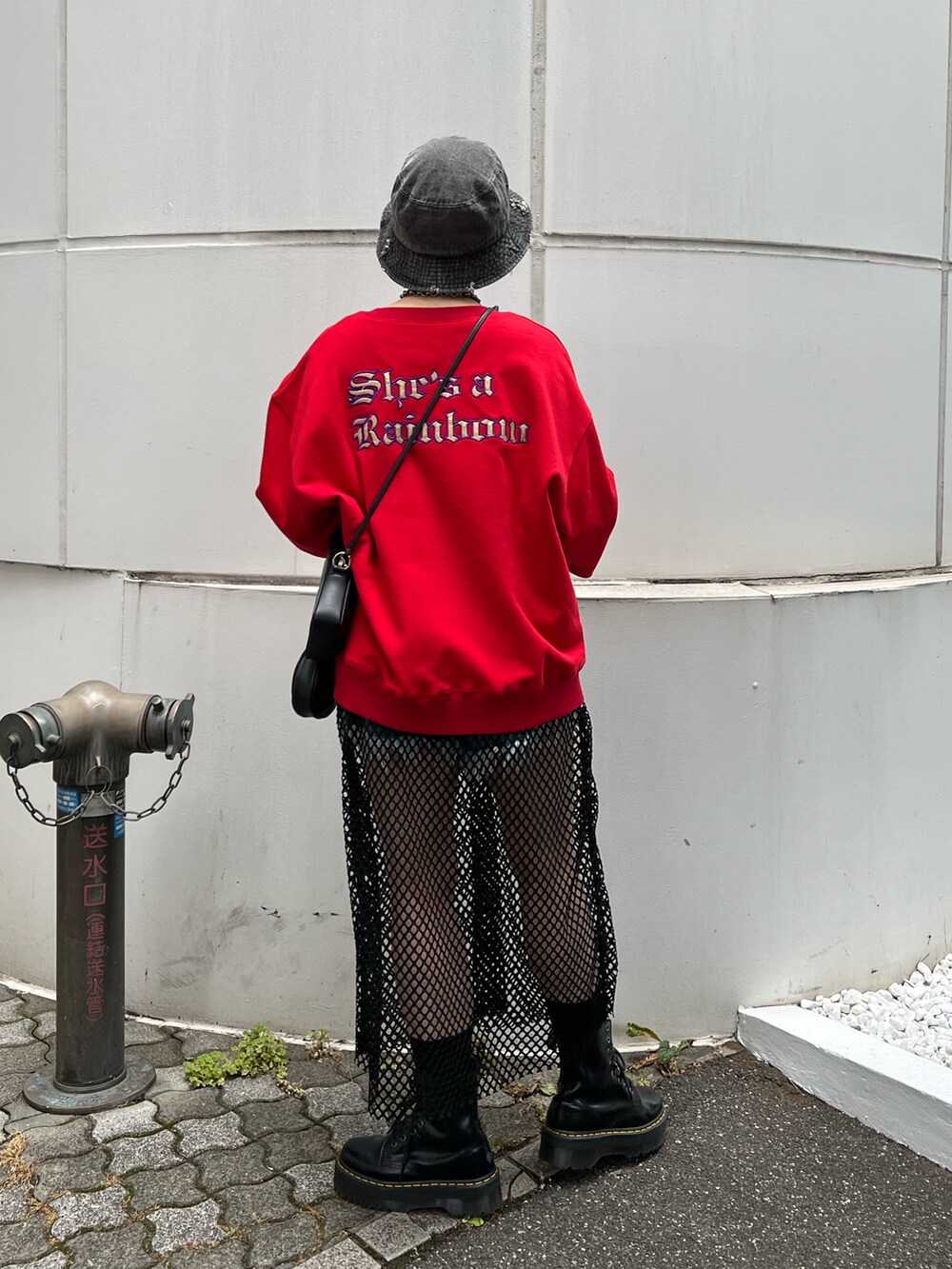 レッド系のスウェット、ブルー系のデニムパンツ、ブラック系のブーツを着用したレディースの秋コーディネートの3枚目の写真