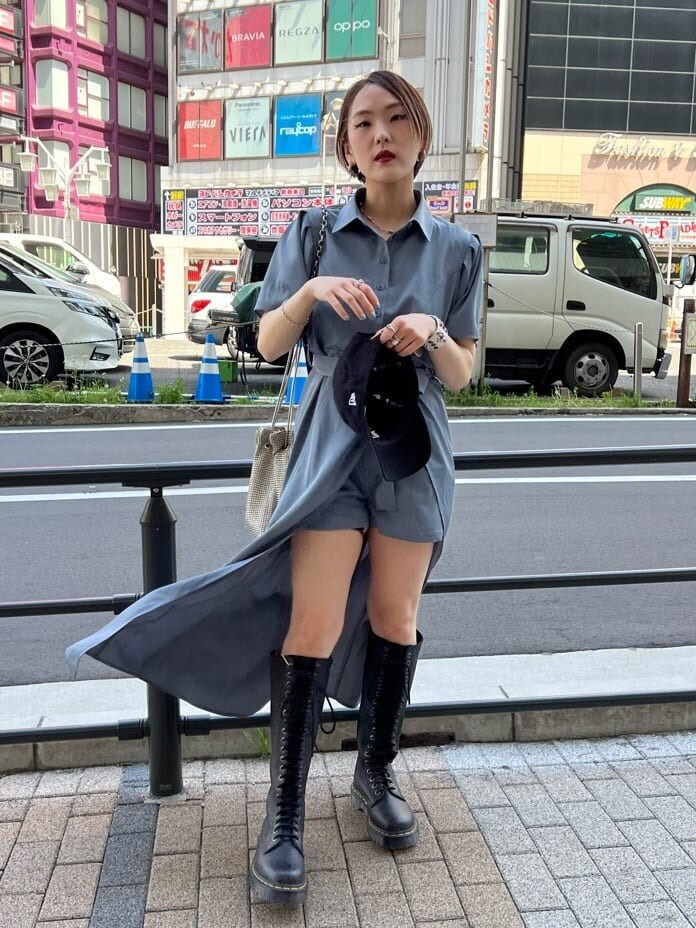 ブラック系のブーツ、グレー系のワンピース、ブラック系のキャップを着用したレディースの夏コーディネートの5枚目の写真