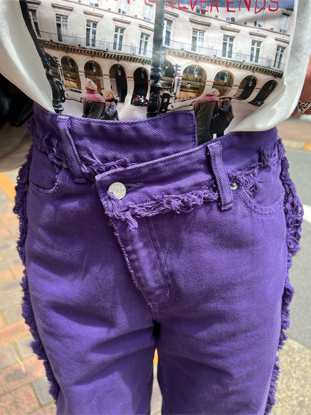 ブラック系のハンドバッグ、ホワイト系のTシャツ/カットソー、パープル系のデニムパンツを着用したレディースの夏コーディネートの8枚目の写真