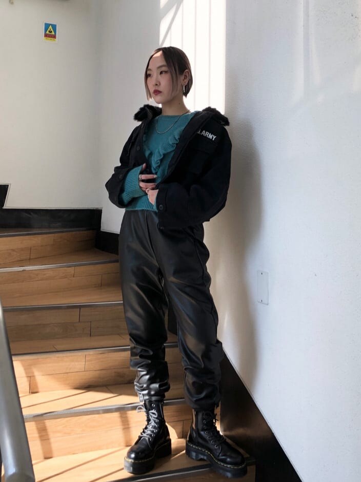 ブラック系のその他パンツ、ブラック系のミリタリージャケット、ブルー系のニット/セーターを着用したレディースの冬コーディネートの2枚目の写真