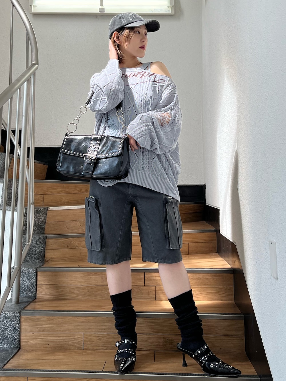 ブラック系のパンプス、ブラック系のカーゴパンツ、ブルー系のキャミソールを着用したレディースの春コーディネートの6枚目の写真