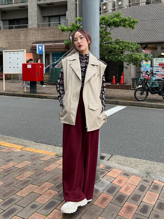 ブラック系のキャミソール、ホワイト系のスニーカー、ホワイト系のライダースジャケットを着用したレディースの秋コーディネートの5枚目の写真