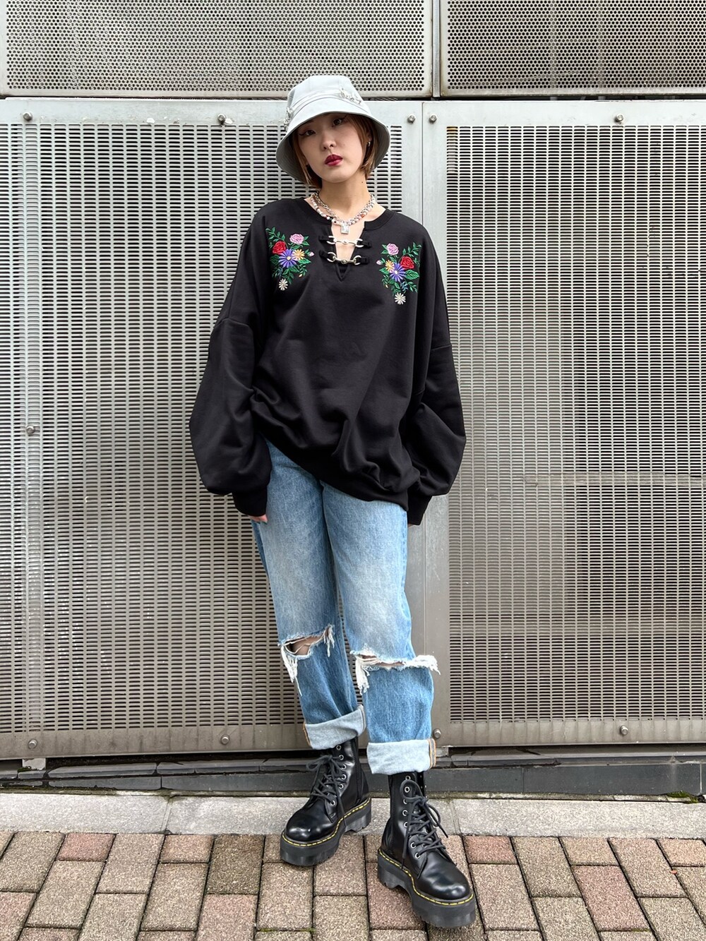ブラック系のTシャツ/カットソー、ブルー系のデニムパンツ、ブラック系のブーツを着用したレディースの秋コーディネートの4枚目の写真