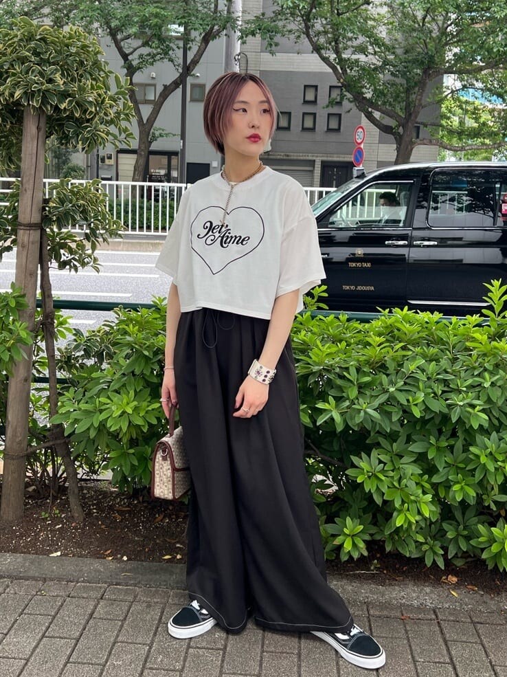 ブラウン系のハンドバッグ、ホワイト系のTシャツ/カットソー、ブラック系のその他パンツを着用したレディースの夏コーディネートの3枚目の写真