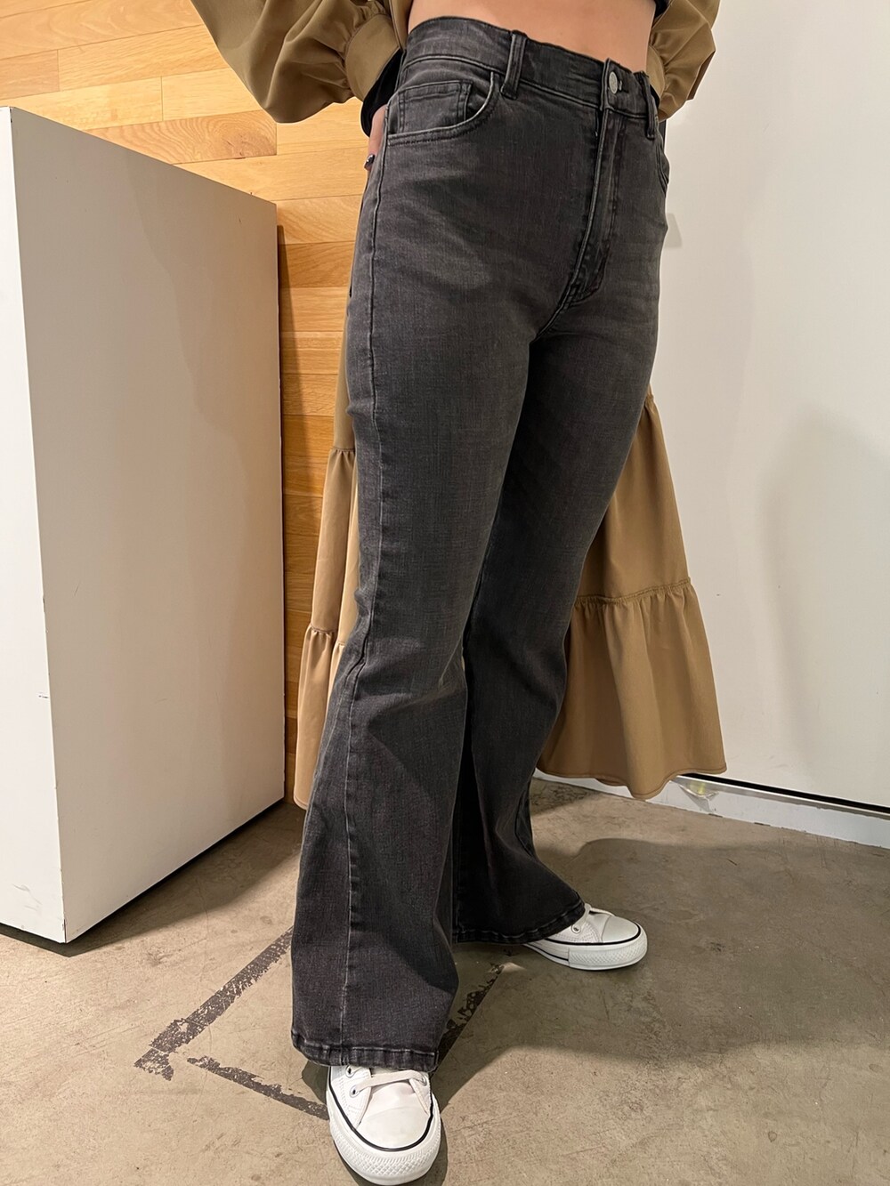 ブラック系のデニムパンツ、ブラック系のTシャツ/カットソー、ベージュ系のワンピースを着用したレディースの秋コーディネートの8枚目の写真