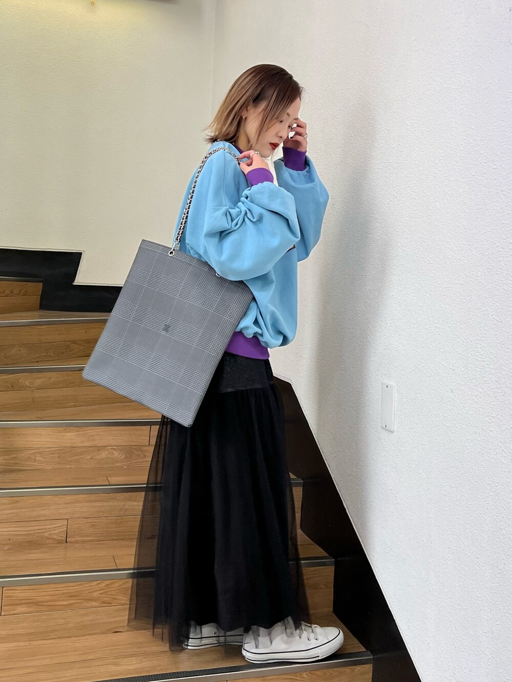 ブルー系のスウェット、ブラック系のスカート、グレー系のトートバッグを着用したレディースの冬コーディネートの2枚目の写真