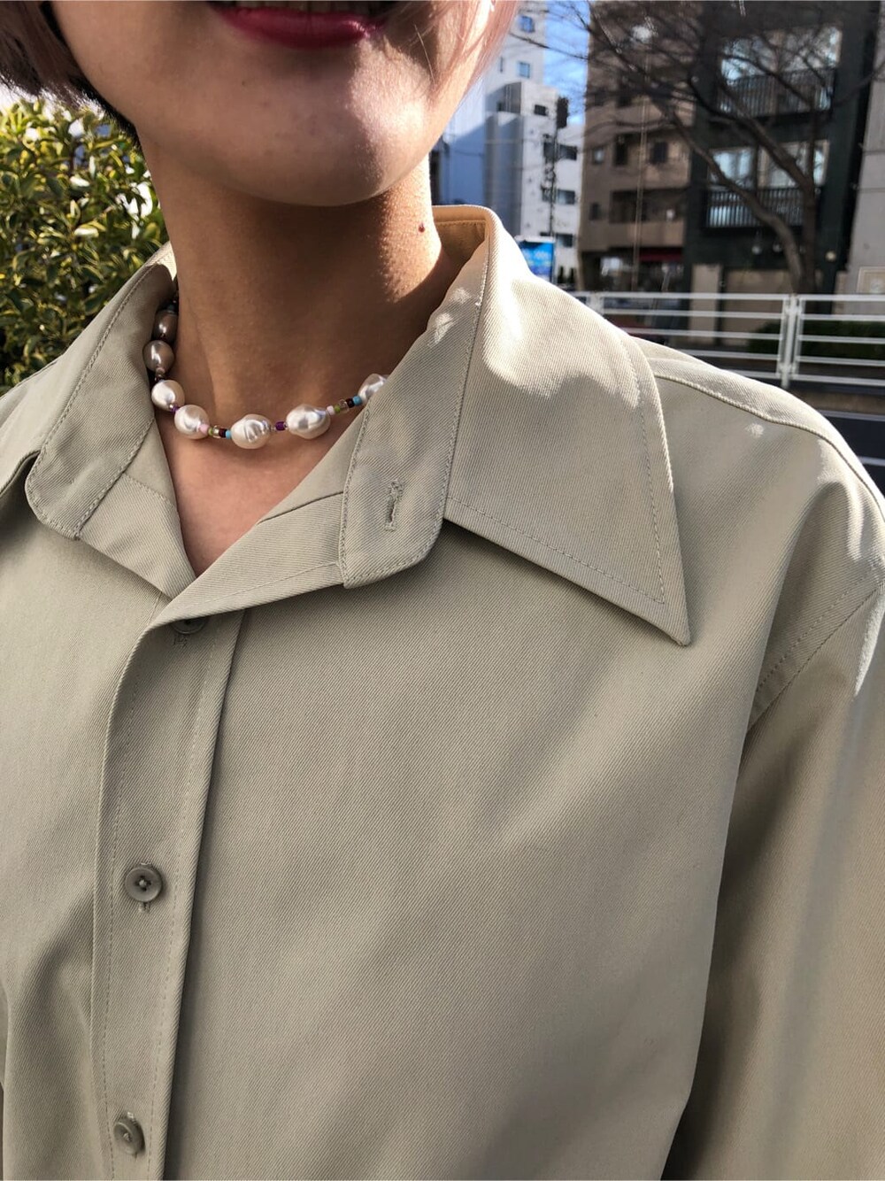 グリーン系のシャツ/ブラウス、ブラック系のスラックスを着用したレディースの春コーディネートの7枚目の写真