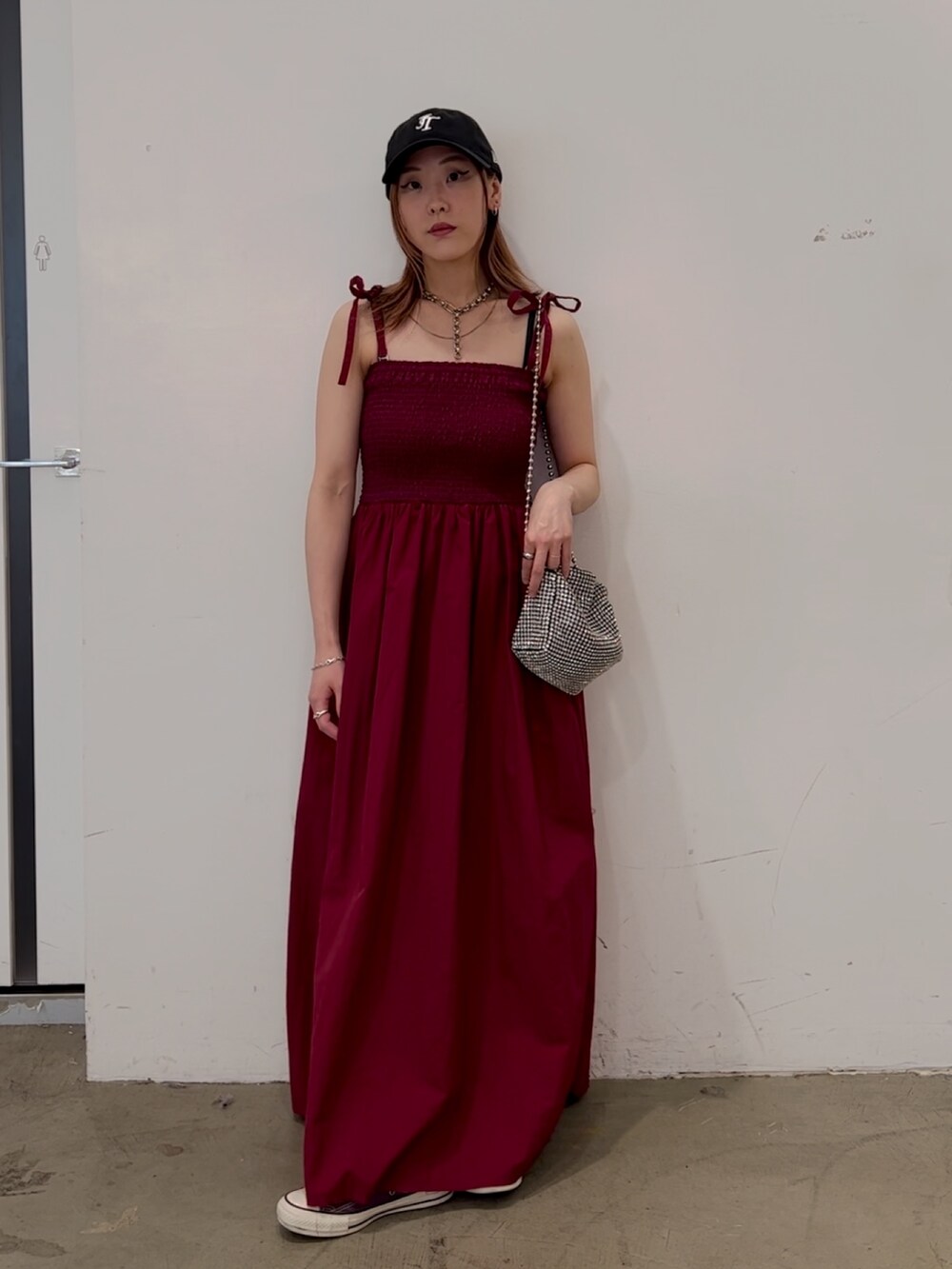 レッド系のワンピース、ホワイト系のショルダーバッグ、パープル系のスニーカーを着用したレディースの夏コーディネートの5枚目の写真