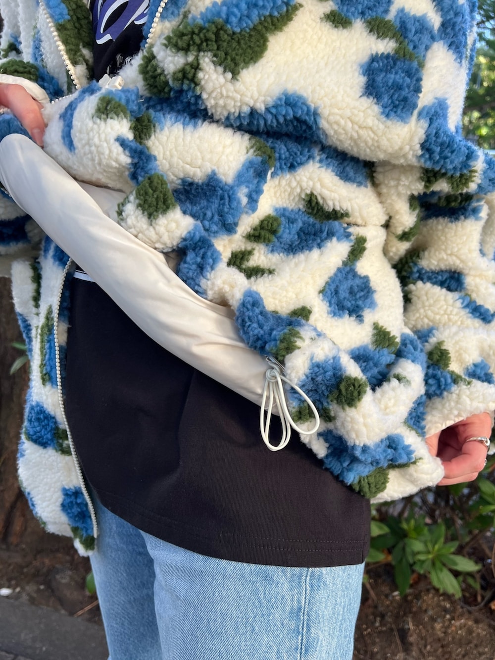 ブラック系のTシャツ/カットソー、ホワイト系のブルゾン、ブラック系のブーツを着用したレディースの夏コーディネートの8枚目の写真