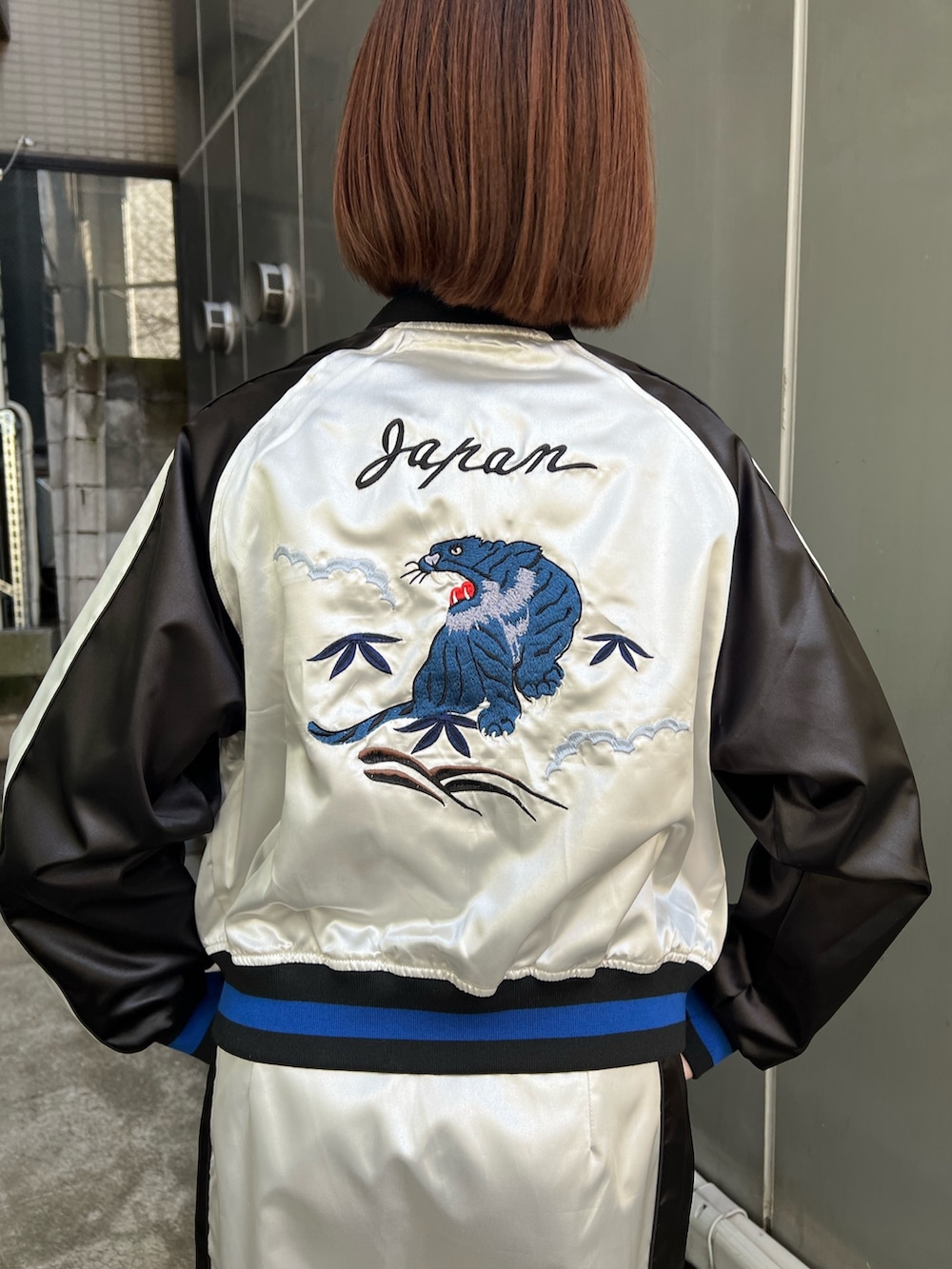 ホワイト系のスカジャン、ホワイト系のスカート、ブラック系のシャツ/ブラウスを着用したレディースの冬コーディネートの6枚目の写真