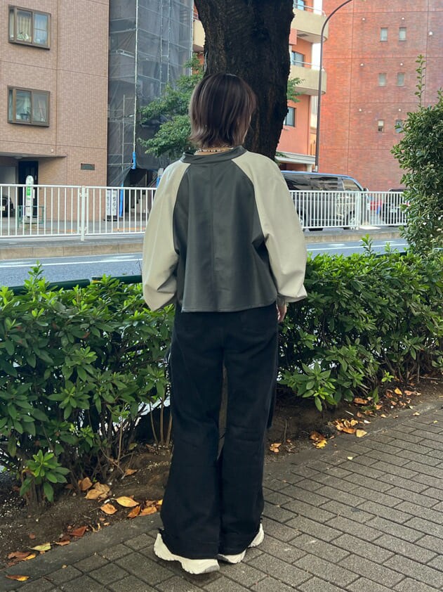 ブラック系のニット/セーター、ホワイト系のスニーカー、ブラック系のデニムパンツを着用したレディースの秋コーディネートの4枚目の写真