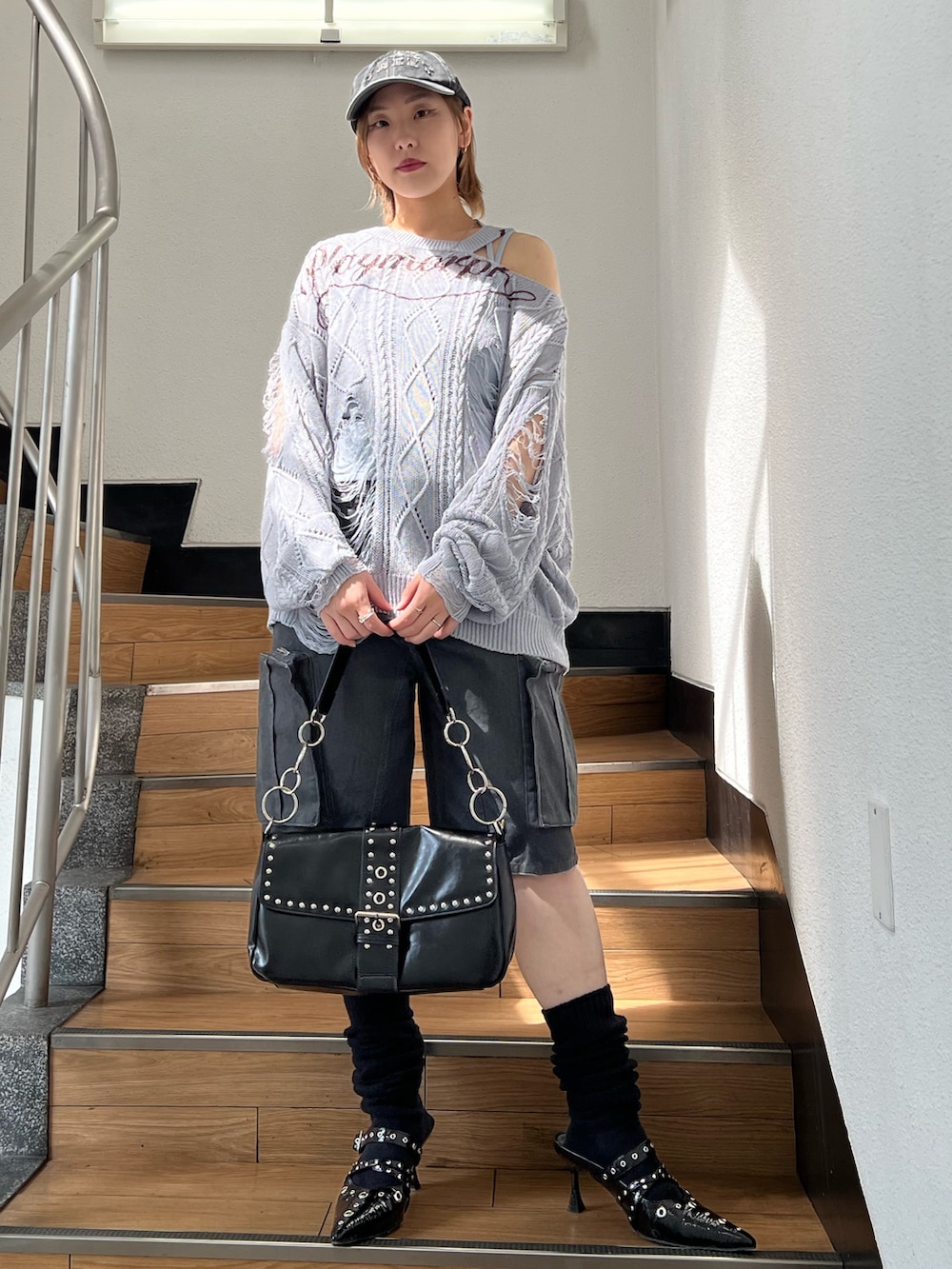 ブラック系のパンプス、ブラック系のカーゴパンツ、ブルー系のキャミソールを着用したレディースの春コーディネートの2枚目の写真