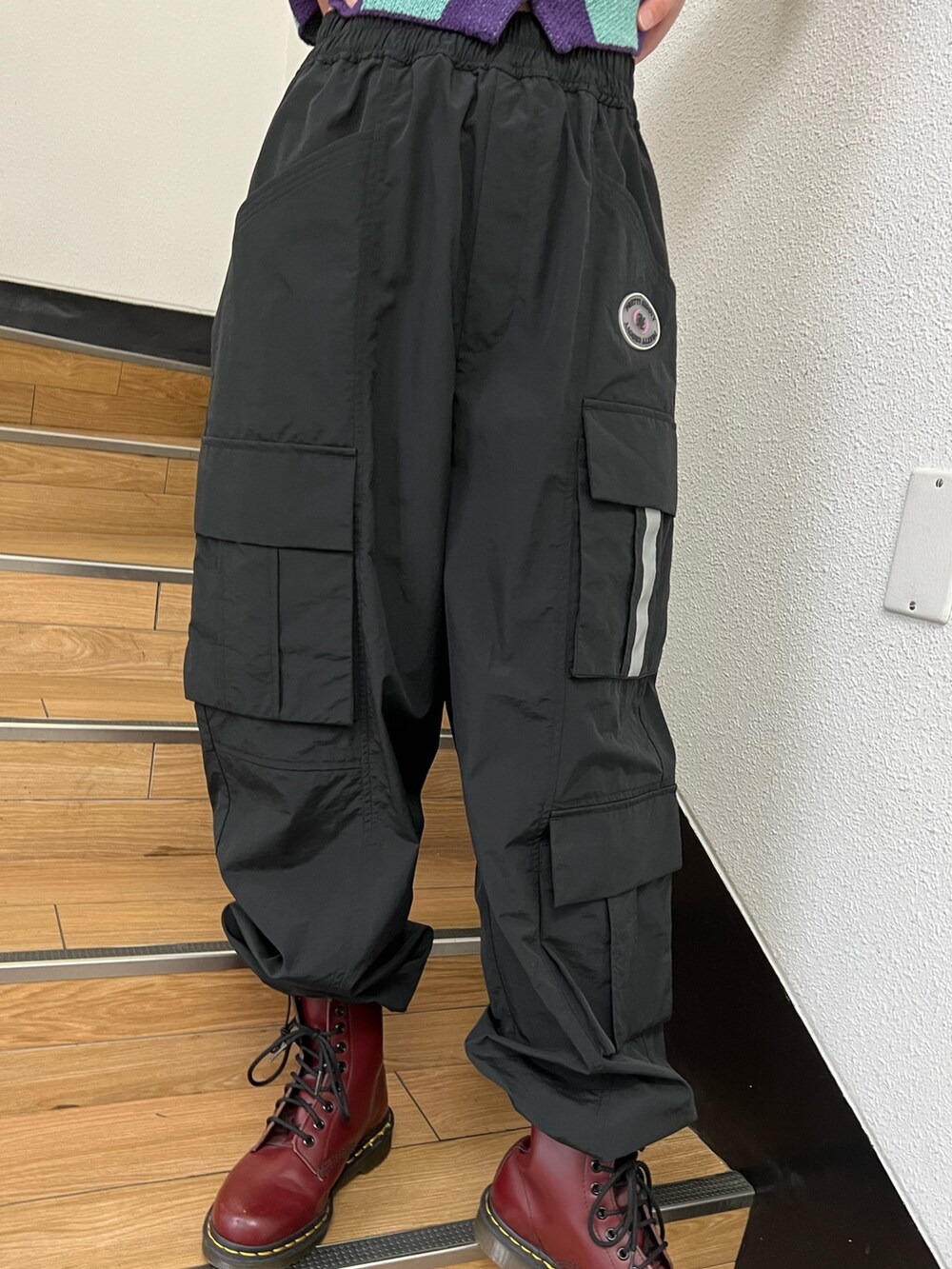 ブラック系のカーゴパンツ、パープル系のカーディガン/ボレロ、ブラック系のキャップを着用したレディースの春コーディネートの7枚目の写真