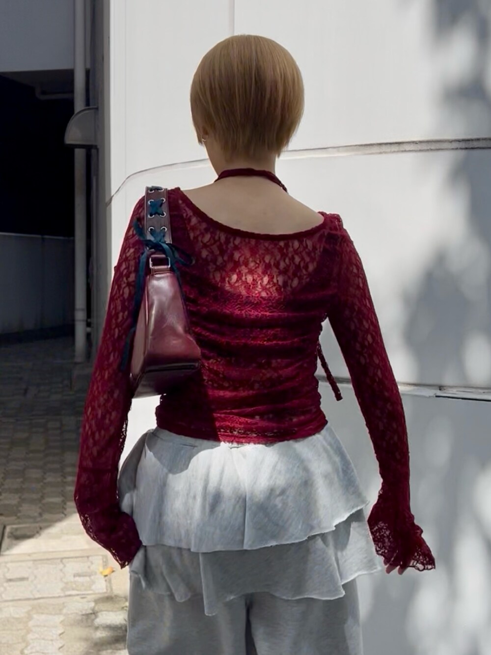 レッド系のTシャツ/カットソー、グレー系のスウェットパンツ、レッド系のハンドバッグを着用したレディースの夏コーディネートの5枚目の写真