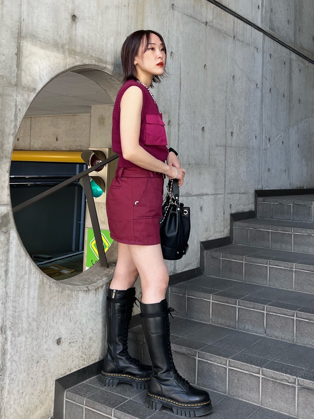 レッド系のその他パンツ、ピンク系のベストを着用したレディースの春コーディネートの2枚目の写真