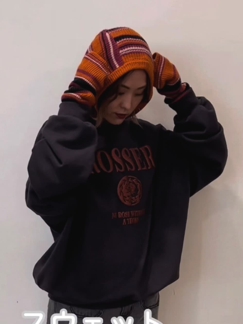 ブラック系のスウェット、ブラック系のデニムパンツ、ピンク系のアームカバーを着用したレディースの秋コーディネートの4枚目の写真