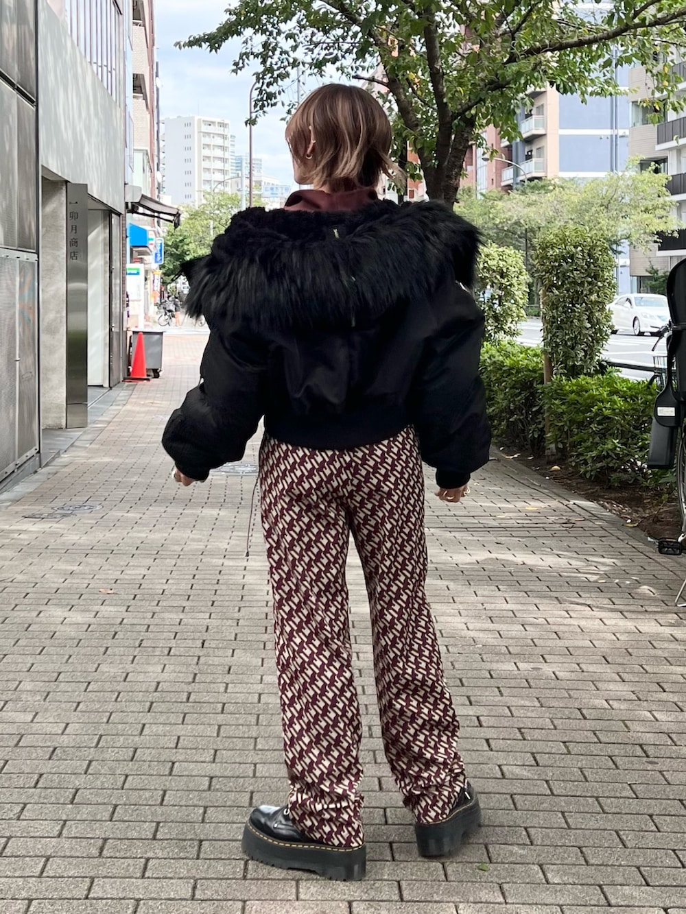 ブラック系のその他アウター、ブラウン系のスウェット、ブラウン系のその他パンツを着用したレディースの冬コーディネートの2枚目の写真