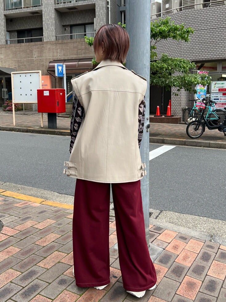 ブラック系のキャミソール、ホワイト系のスニーカー、ホワイト系のライダースジャケットを着用したレディースの秋コーディネートの3枚目の写真