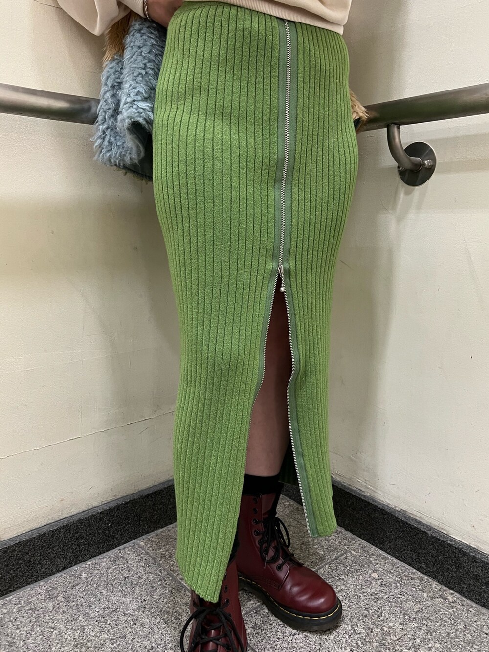 その他のベスト、ホワイト系のニット/セーター、グリーン系のスカートを着用したレディースの冬コーディネートの6枚目の写真