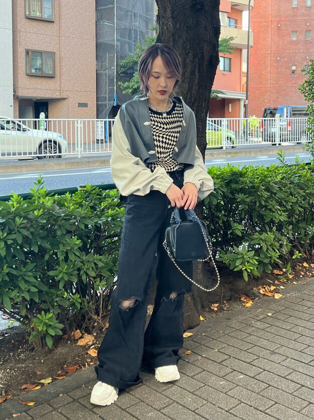 ブラック系のニット/セーター、ホワイト系のスニーカー、ブラック系のデニムパンツを着用したレディースの秋コーディネートの5枚目の写真