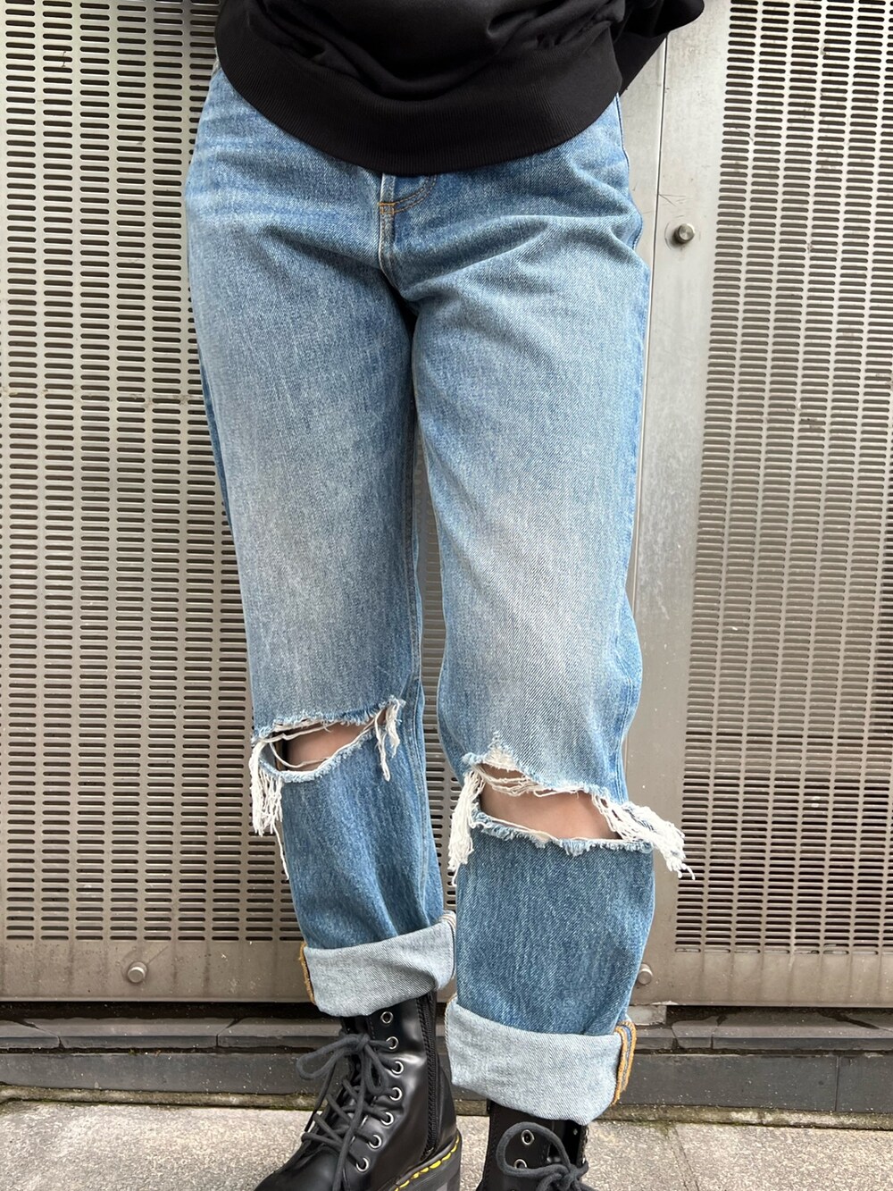 ブラック系のTシャツ/カットソー、ブルー系のデニムパンツ、ブラック系のブーツを着用したレディースの秋コーディネートの9枚目の写真