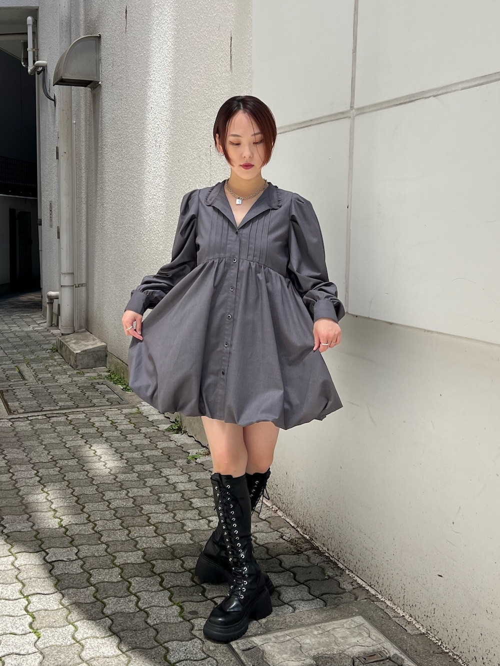 グレー系のワンピース、ブラック系のブーツを着用したレディースの夏コーディネートの4枚目の写真