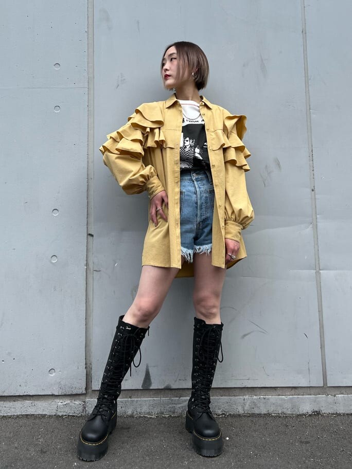 ブルー系のデニムパンツ、ブラック系のブーツ、イエロー系のシャツ/ブラウスを着用したレディースの春コーディネートの2枚目の写真