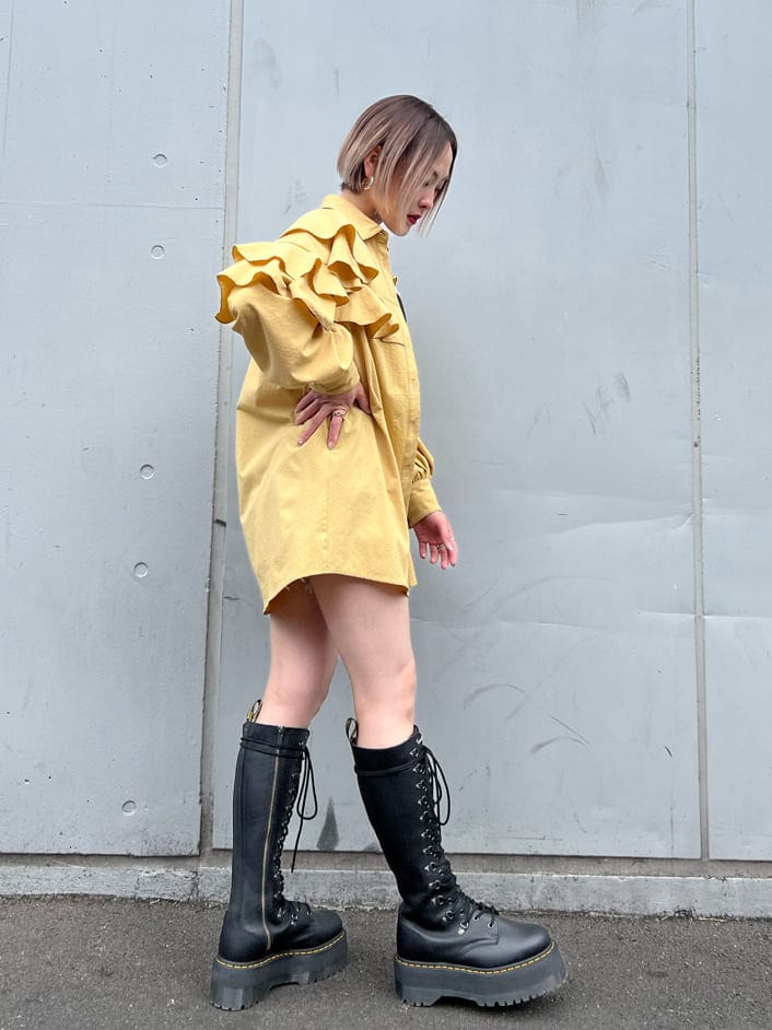 ブルー系のデニムパンツ、ブラック系のブーツ、イエロー系のシャツ/ブラウスを着用したレディースの春コーディネートの3枚目の写真