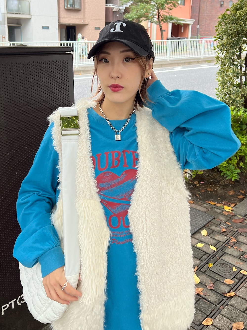 ブルー系のTシャツ/カットソー、ホワイト系のベスト、ホワイト系のハンドバッグを着用したレディースの冬コーディネートの4枚目の写真