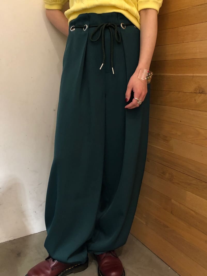 グリーン系のスラックス、イエロー系のニット/セーター、シルバー系のネックレスを着用したレディースの冬コーディネートの8枚目の写真