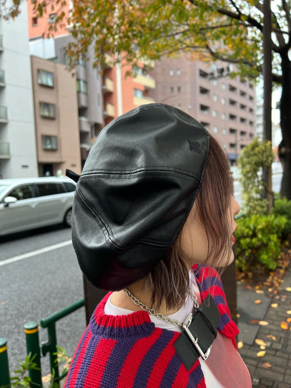 レッド系のニット/セーター、パープル系のTシャツ/カットソー、ブルー系のデニムパンツを着用したレディースの冬コーディネートの9枚目の写真