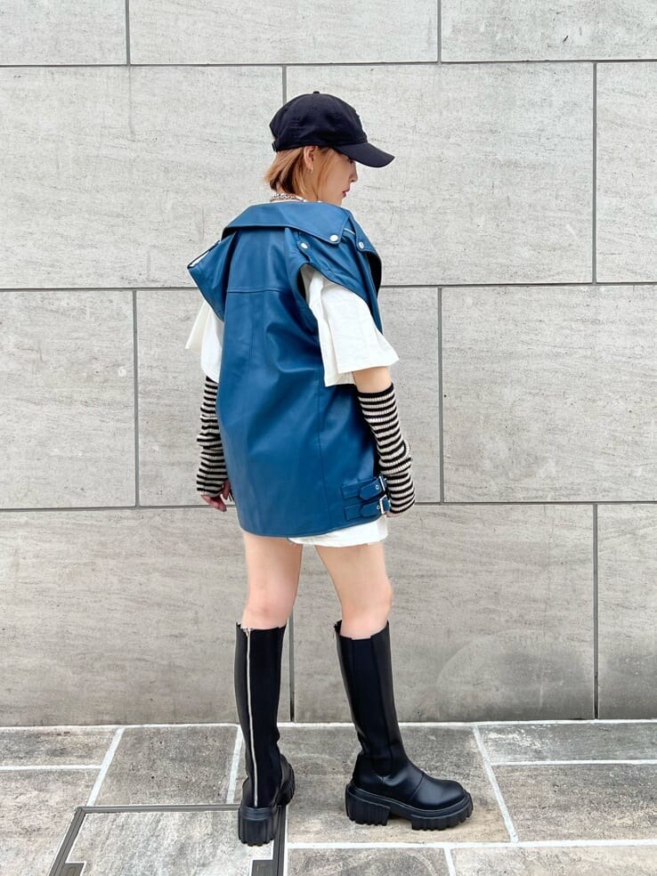 ブラック系のデニムパンツ、ホワイト系のTシャツ/カットソー、ブラック系のブーツを着用したレディースの秋コーディネートの4枚目の写真