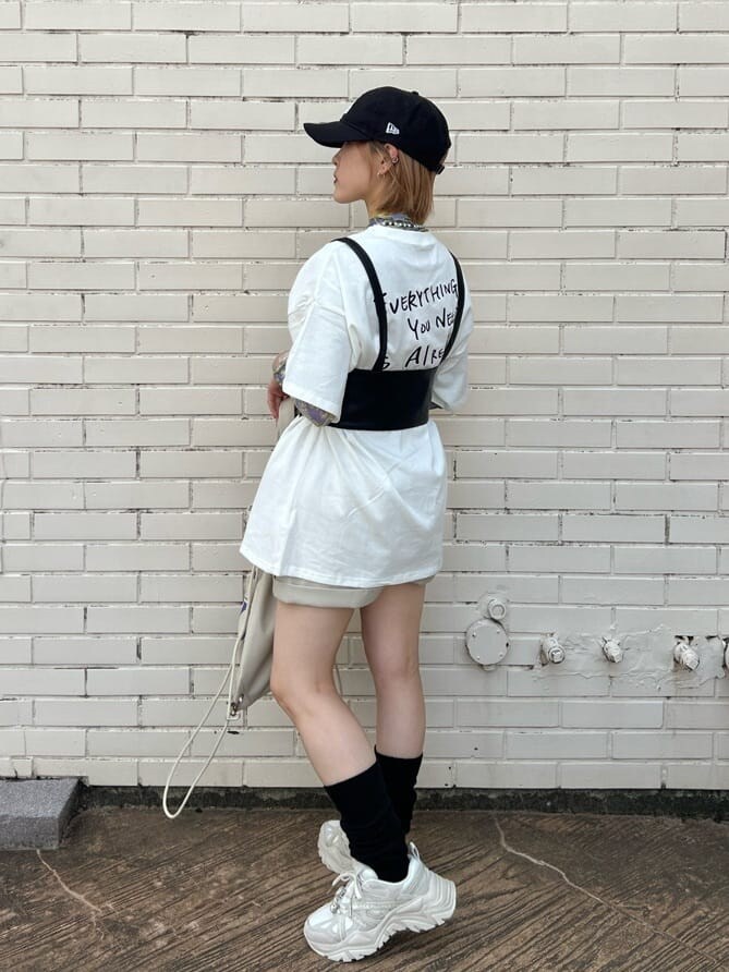 ホワイト系のスニーカー、ホワイト系のバックパック/リュック、ホワイト系のTシャツ/カットソーを着用したレディースの秋コーディネートの3枚目の写真