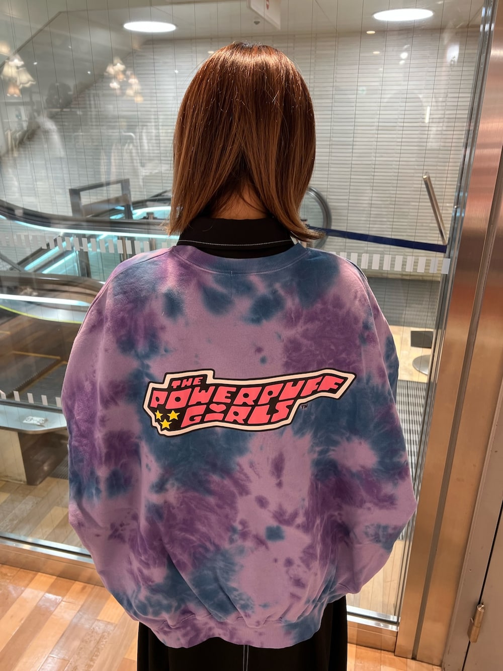 パープル系のスウェット、ブラック系のワンピース、ブラック系のローファーを着用したレディースの春コーディネートの9枚目の写真