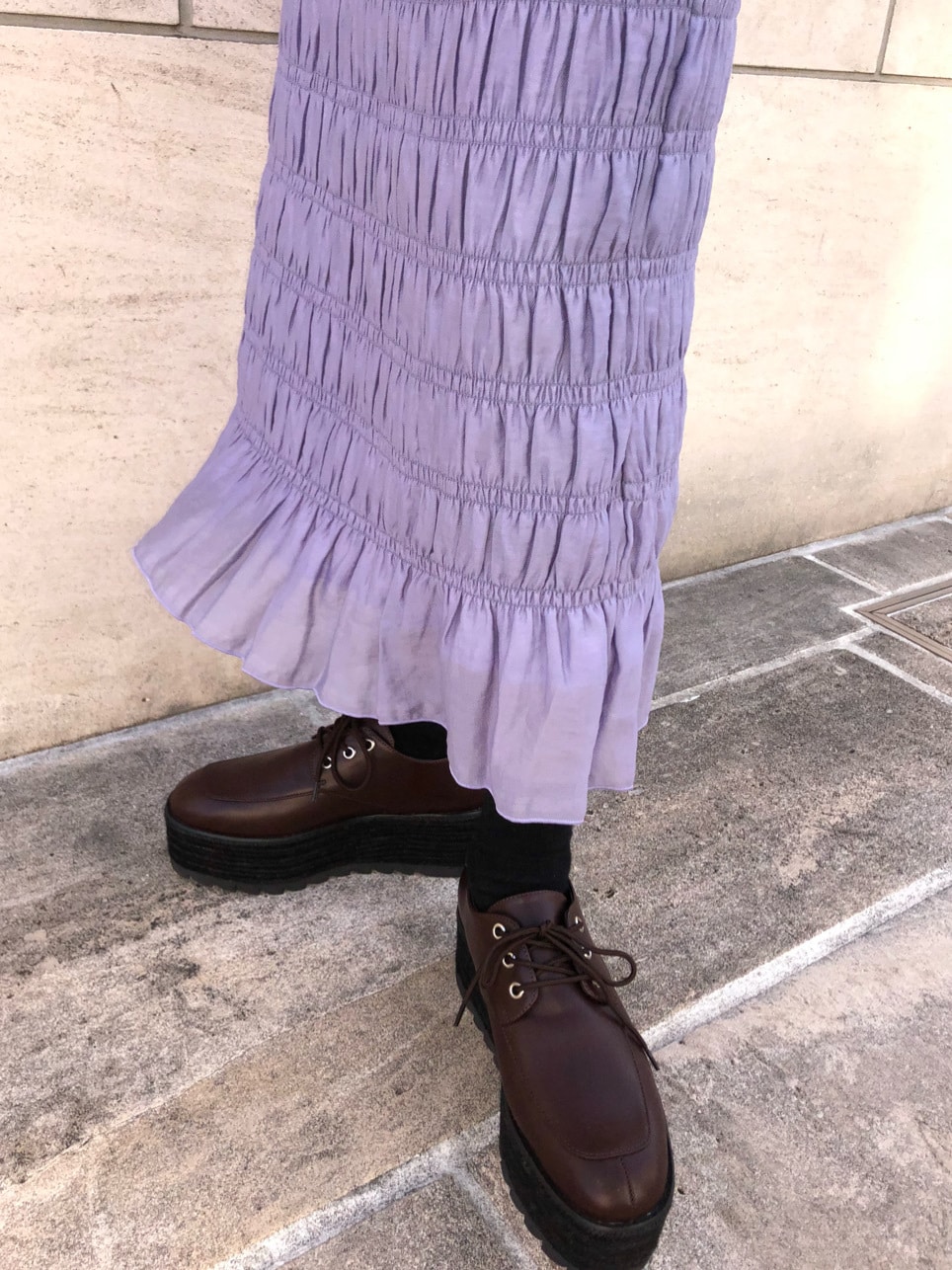 その他のショルダーバッグ、パープル系のスカート、ブラウン系のローファーを着用したレディースの春コーディネートの6枚目の写真
