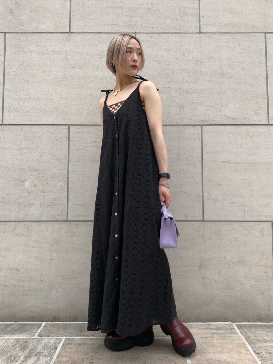 レッド系のブーツ、ホワイト系のセットアップ、ブラック系のワンピースを着用したレディースの春コーディネートの7枚目の写真