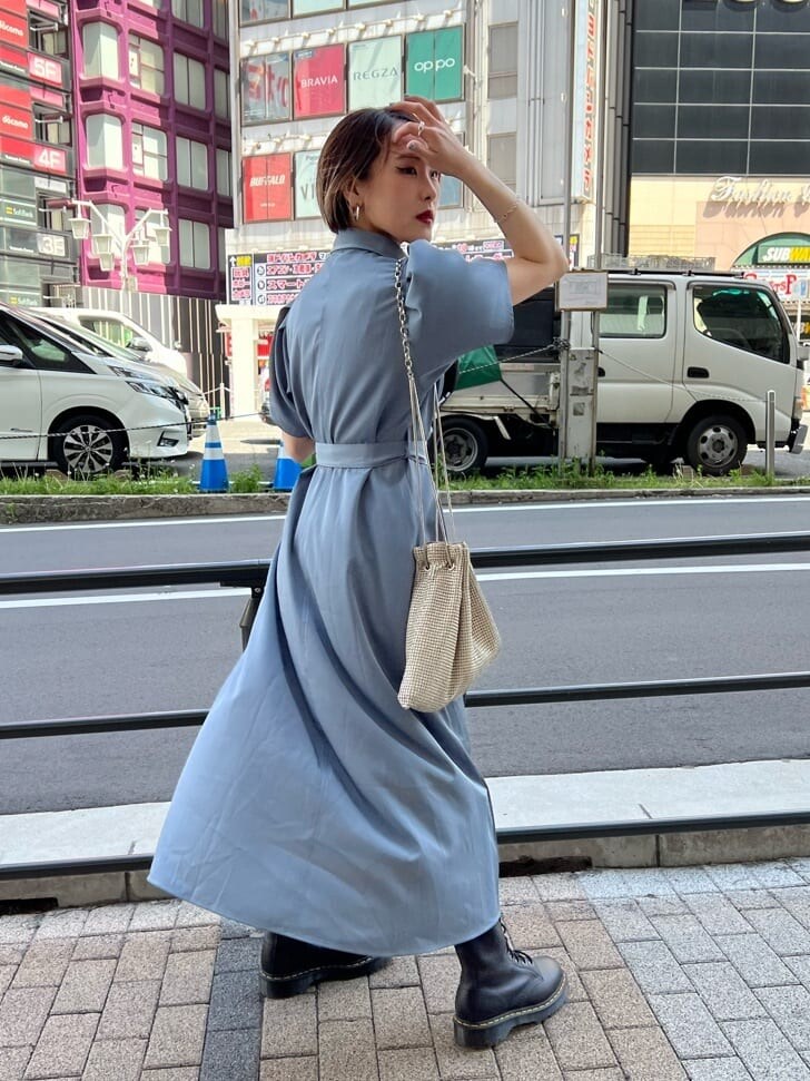 ブラック系のブーツ、グレー系のワンピース、ブラック系のキャップを着用したレディースの夏コーディネートの3枚目の写真