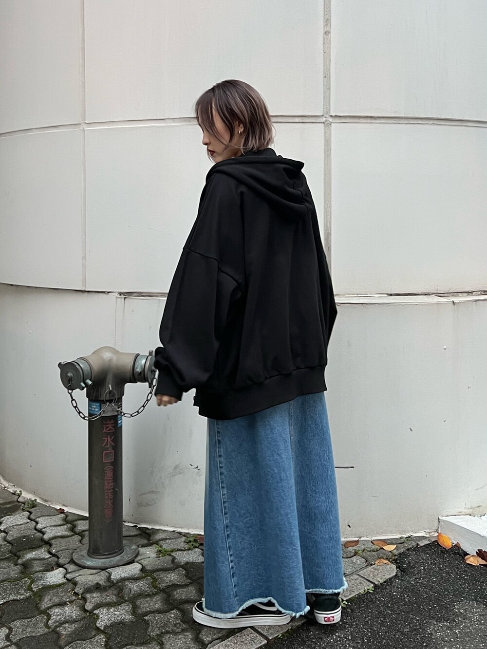 ブルー系のスカート、ブラック系のパーカー、ブルー系のタンクトップを着用したレディースの春コーディネートの5枚目の写真